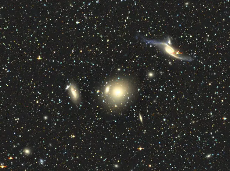 A star field with several galaxies of different shapes visible in the centre